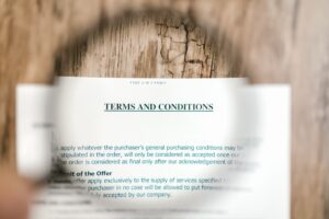 Magnifying glass over a terms and conditions document, representing AI Act compliance review