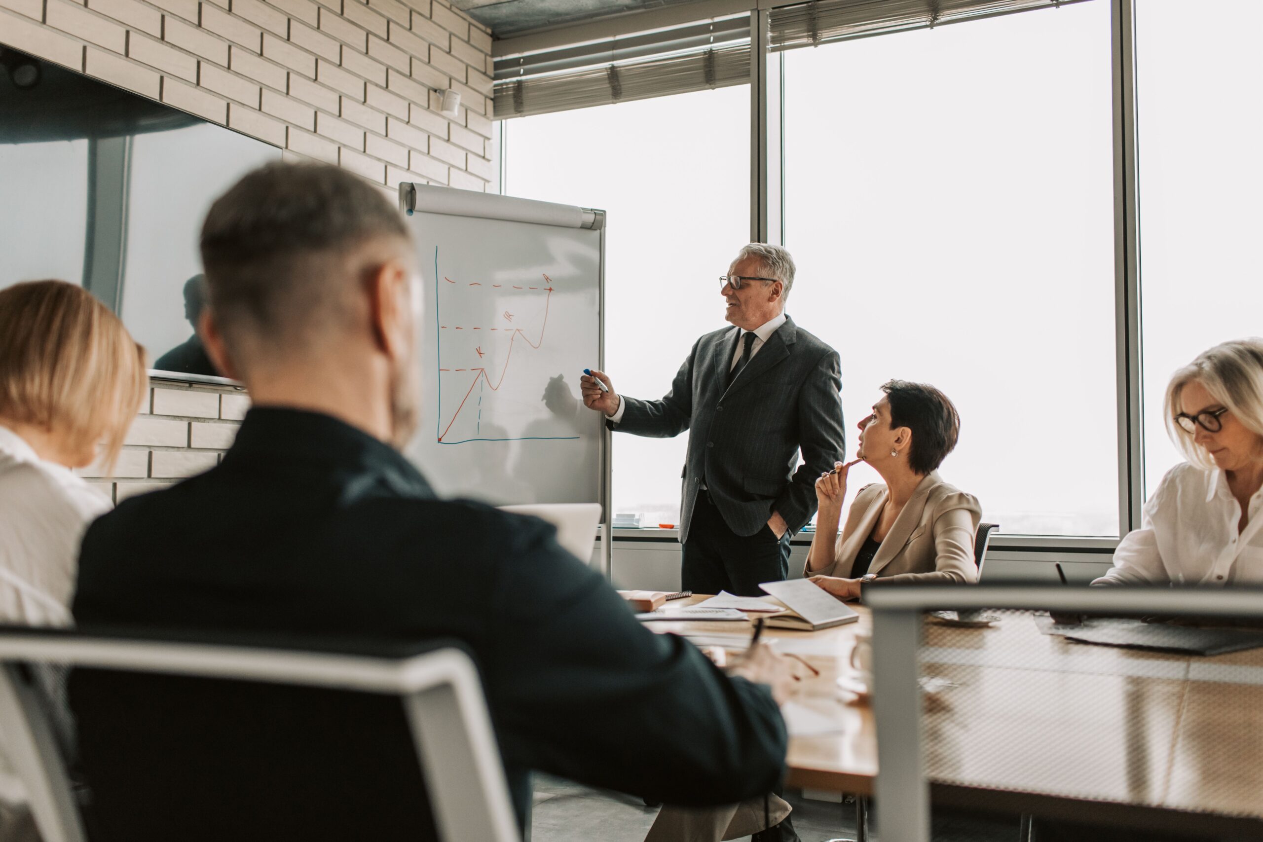 Senior marketing leader presenting growth charts in a boardroom meeting, representing the evolving CMO role in the age of AI